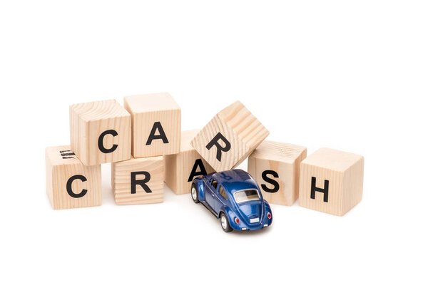 blue toy car and wooden blocks with letters on white