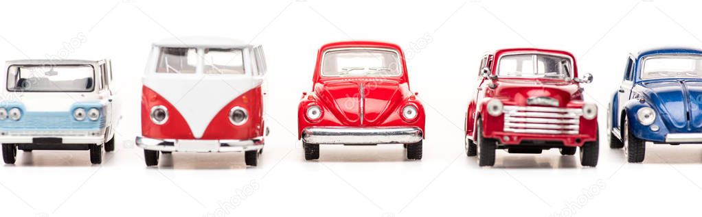 panoramic shot of colorful toy cars and bus on white