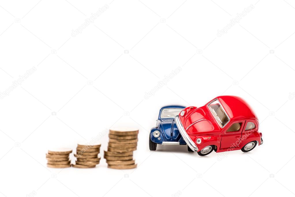 auto giocattolo rosse e blu e monete d'oro su bianco