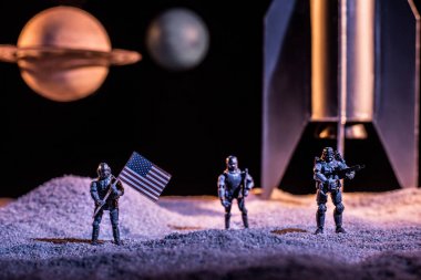 toy soldiers holding american flag in space near rocket and planets clipart