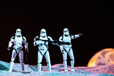 white imperial stormtroopers with weapon on cosmic planet isolated on black