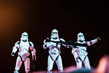 selective focus of white imperial stormtroopers with guns on cosmic planet