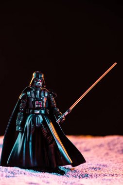 Darth Vader figurine with lightsaber isolated on black
