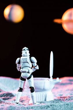 white imperial stormtrooper using toy toilet in space  