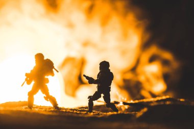 toy soldiers silhouettes with guns on planet with sun in smoke on background clipart