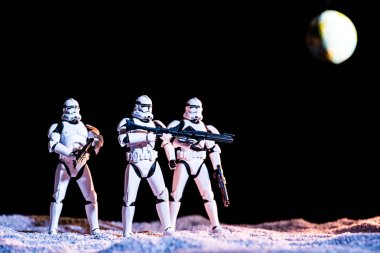 white imperial stormtroopers with guns in space on black background with planet Earth