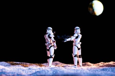 white imperial stormtroopers with gun on black background with planet Earth