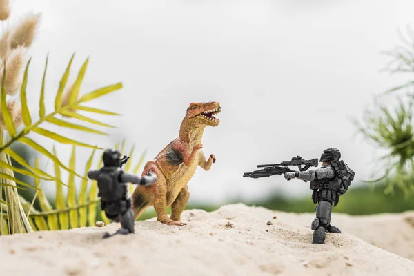 Soldatini Giocattolo Puntando Con Pistole Dinosauro Giocattolo Sulla Collina Sabbia — Foto Stock