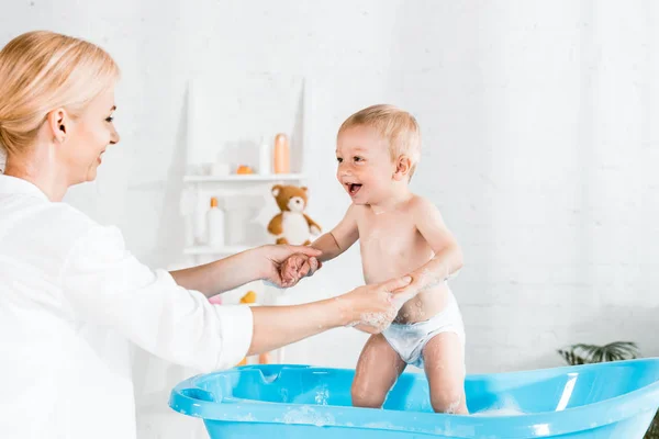 Glückliche Mutter Hält Händchen Mit Fröhlichem Kleinkind Sohn Badezimmer — Stockfoto