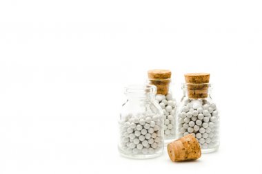 glass bottles with round small pills and wooden corks isolated on white 