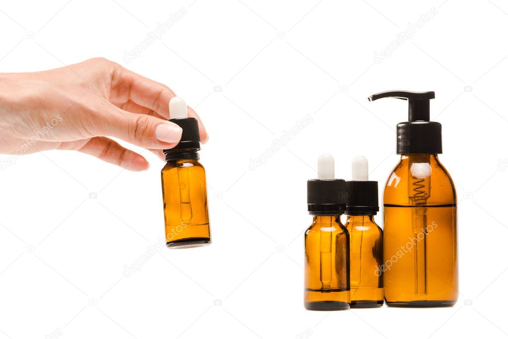 cropped view of woman taking bottle with serum isolated on white 