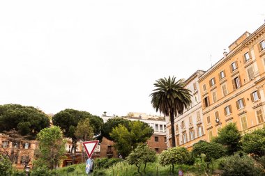 yol işareti, roma, İtalya renkli binaların yakınında yeşil ağaçlar ve çalılar