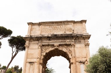 Roma, İtalya - 28 Haziran 2019: Titus Kemeri ve gri gökyüzünün altındaki yeşil ağaçlar