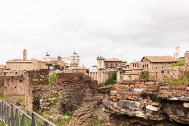 roma, İtalya gri gökyüzü altında binalar ve yıkılmış tuğla duvarlar