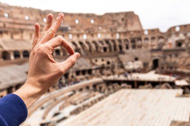 Roma, İtalya - 28 Haziran 2019: Kolezyum önünde tamam işareti gösteren adam kırpılmış görünümü