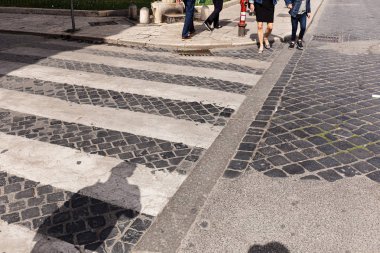cropped view of people at crosswalk in rome, italy clipart