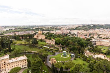 Roma, İtalya - 28 Haziran 2019: Roma'da gri gökyüzü altındaki bina ların ve ağaçların havadan görünümü, İtalya