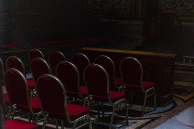 Roma, İtalya - 28 Haziran 2019: Roma'daki karanlık kilisede kırmızı sandalyeler, İtalya