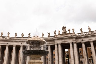 Roma, İtalya - 28 Haziran 2019: Roma heykelleri ve çeşme ile antik bina Roma, İtalya bulutlu gökyüzü altında