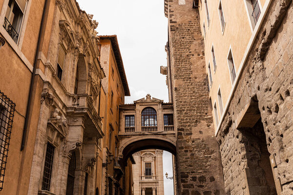 old buildings with bas-reliefs under grey sky in rome, italy