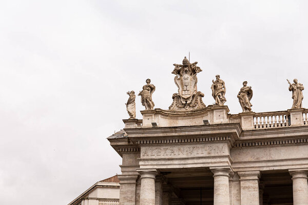 ROME, ITALY - JUNE 28, 2019: ancient building with roman sculptures under overcast sky