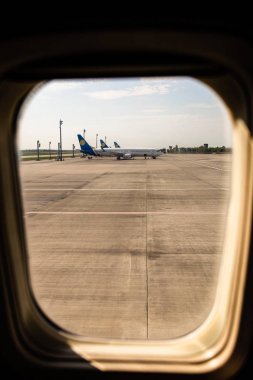 ROME, ITALY - JUNE 28, 2019: airplanes at aerodrome behind plane window in rome, italy clipart