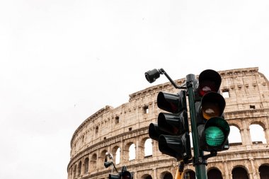 Roma, İtalya - 28 Haziran 2019: gri gökyüzünün altında kolezyum ve trafik ışığı