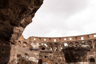 Roma, İtalya - 28 Haziran 2019: Gri gökyüzü altında kolezyum ve turist kalıntıları
