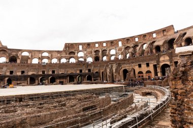 Roma, İtalya - 28 Haziran 2019: Gri gökyüzü altında kolezyum ve turist kalıntıları