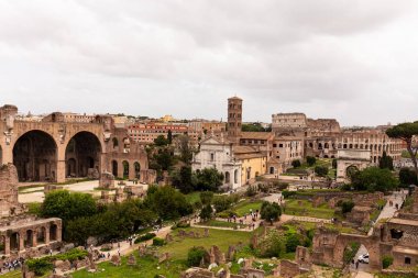 Roma, İtalya - 28 Haziran 2019: Gri gökyüzü altında Roma forumu etrafında yürüyen turistler