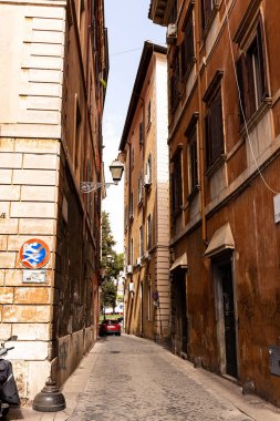 Roma, İtalya - 28 Haziran 2019: roma güneşli bir günde dar sokak ve kırmızı araba, İtalya