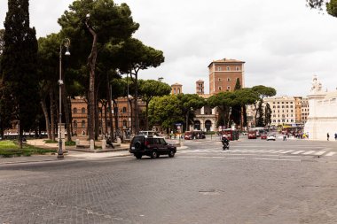 ROME, ITALY - JUNE 28, 2019: people, cars and buses on street  clipart