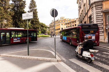ROME, ITALY - JUNE 28, 2019: people, buses and cars on street in sunny day clipart