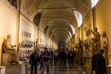ROME, ITALY - JUNE 28, 2019: crowd of tourists walking in old museum with exhibition clipart