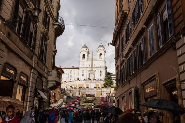 Roma, İtalya - 28 Haziran 2019: bulutlu gökyüzünün altındaki pld binaların ın yakınında şemsiyeli turist kalabalığı