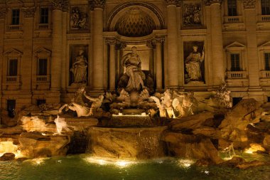 Roma, İtalya - 28 Haziran 2019: Akşam antik binanın yakınında çeşme ve antikheykeller