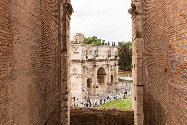 ROME, ITALY - JUNE 28, 2019: group of tourists near near arch of Constantine under overcast sky