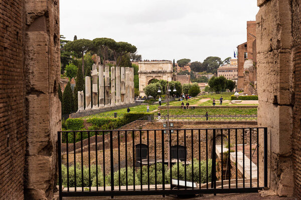 ROME, ITALY - JUNE 28, 2019: crowd of tourists near ancient buildings at roman forum