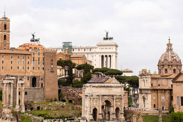 ROME, ITALY - JUNE 28, 2019: tourists walking at roman forum with ancients buildings