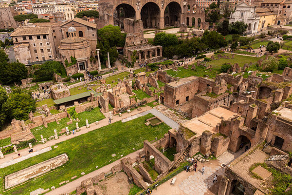 ROME, ITALY - JUNE 28, 2019: tourists walking around roman forum under grey sky