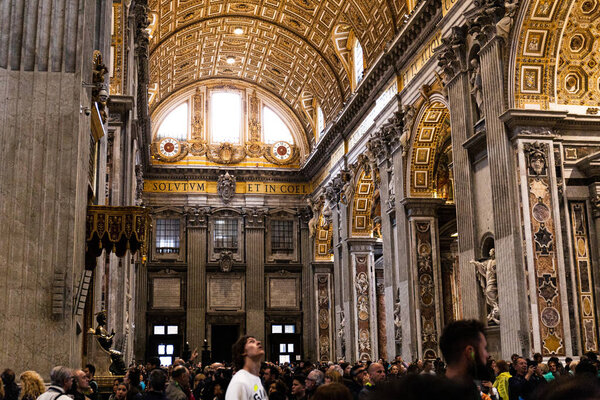 ROME, ITALY - JUNE 28, 2019: crowd of tourists walking and looking around in vatican museums