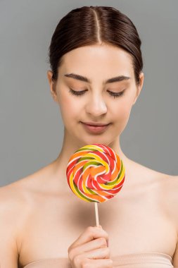 gri izole renkli lolipop tutan neşeli genç kadın 