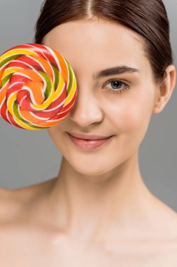 gri izole renkli lolipop ile göz kapsayan mutlu çıplak kadın 