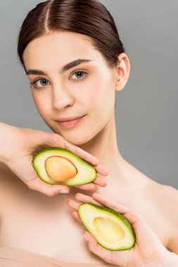 gri izole avokado yarım tutan güzel genç kadın 