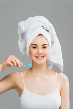 gri izole diş fırçası tutan kafasına havlu ile neşeli genç kadın 