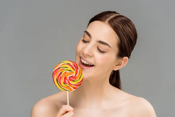 Vrolijke Jonge Vrouw Kijkt Naar Kleurrijke Lollipop Geïsoleerd Grijs — Stockfoto