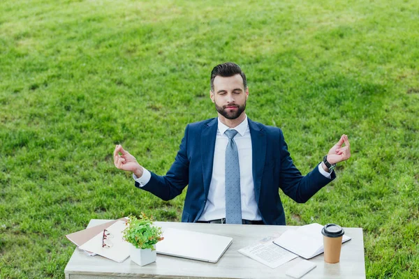Schöner Junger Geschäftsmann Meditiert Während Park Hinter Einem Tisch Sitzt — Stockfoto