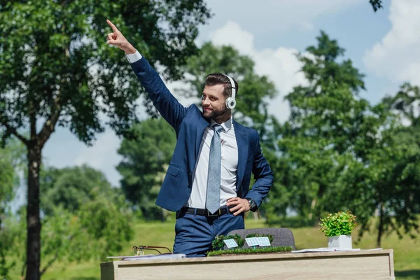Молодой Бизнесмен Слушает Музыку Наушниках Танцует Парке Возле Стола Раскладкой — стоковое фото