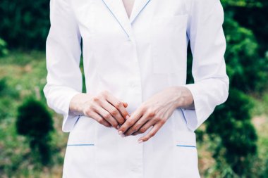parkta duran beyaz ceketli doktorun kırpılmış görünümü