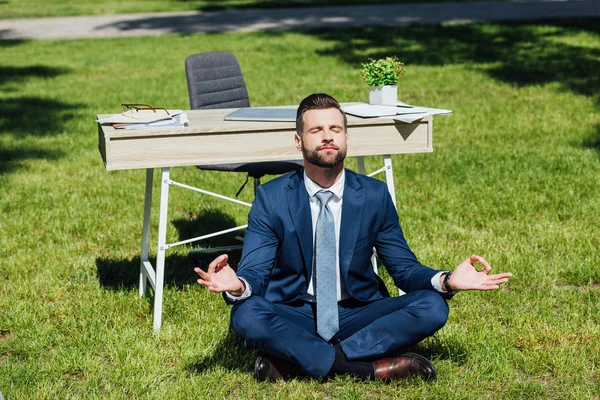 Üzletember Fűben Meditál Közelében Asztal Park — Stock Fotó